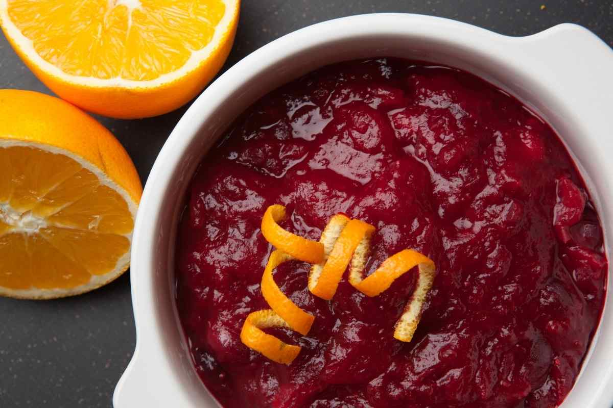 cranberry sauce in a white bowl with orange peel on top