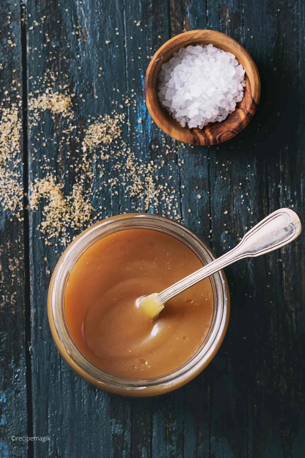 Salted Caramel Sauce in a glass jar with spoon