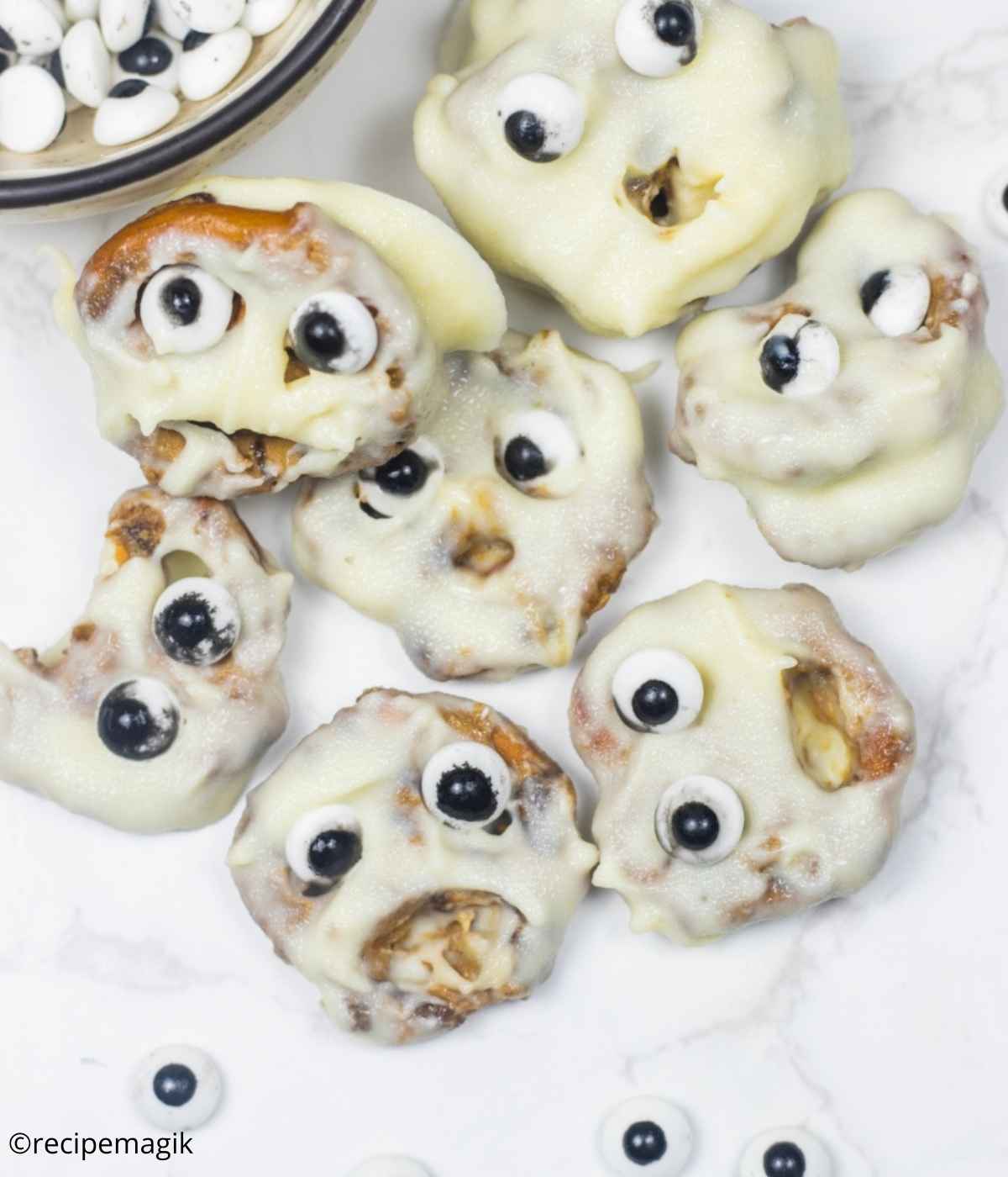 halloween pretzels coated in white chocolate and decorated with candy eyeballs