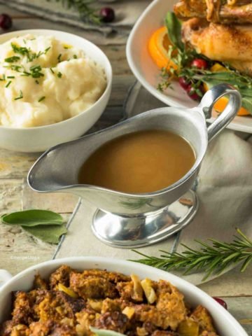 turkey gravy in a gravy boat with turkey on the side
