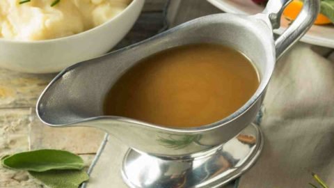 turkey gravy in a gravy boat with turkey on the side