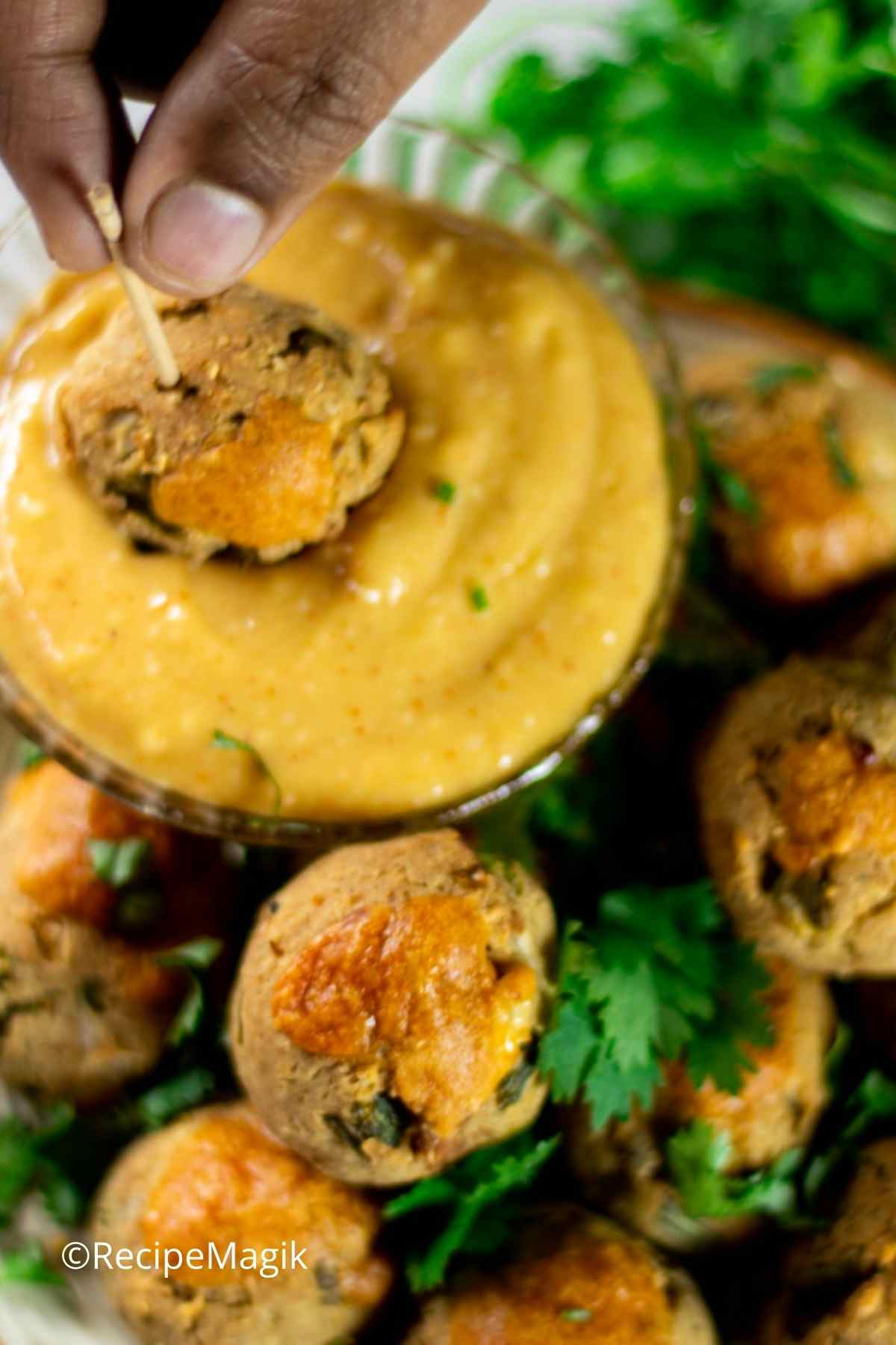 dipping one sausage and cheese ball in honey mustard sauce