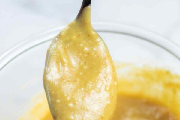 honey mustard sauce dipping from spoon
