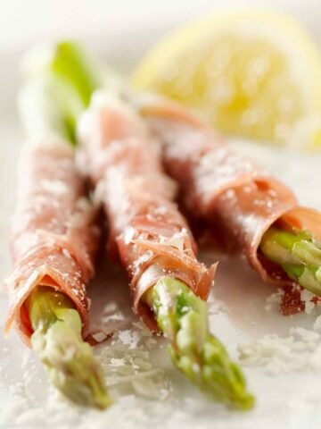 asparagus wrapped with prosciutto and topped with lemon and parmesan
