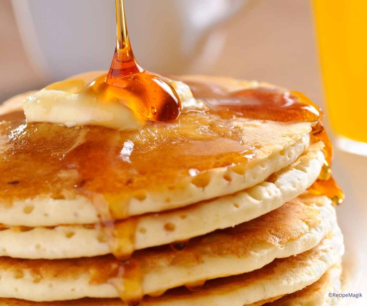 pouring maple on pancakes
