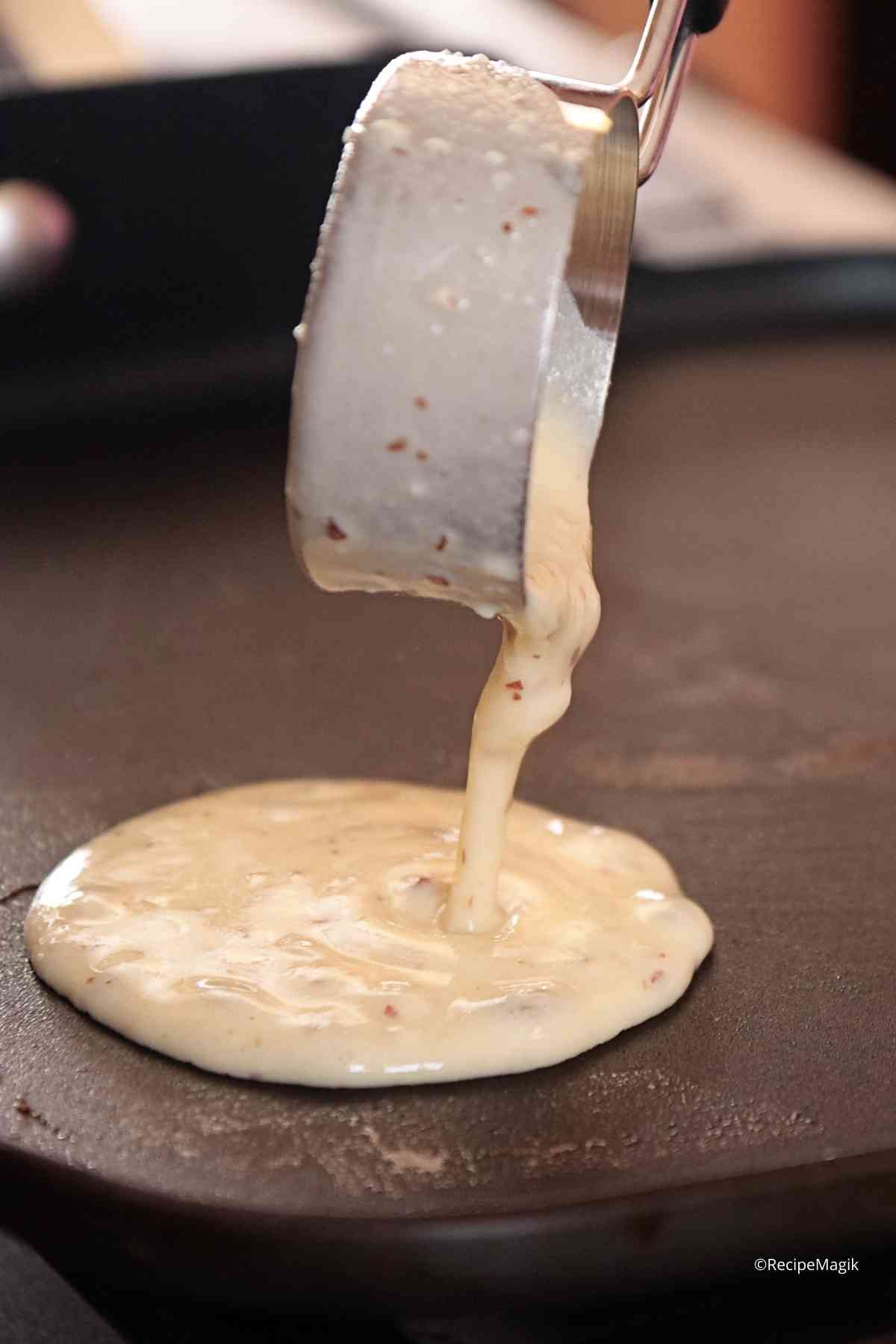 pouring pancake batter into a griddle