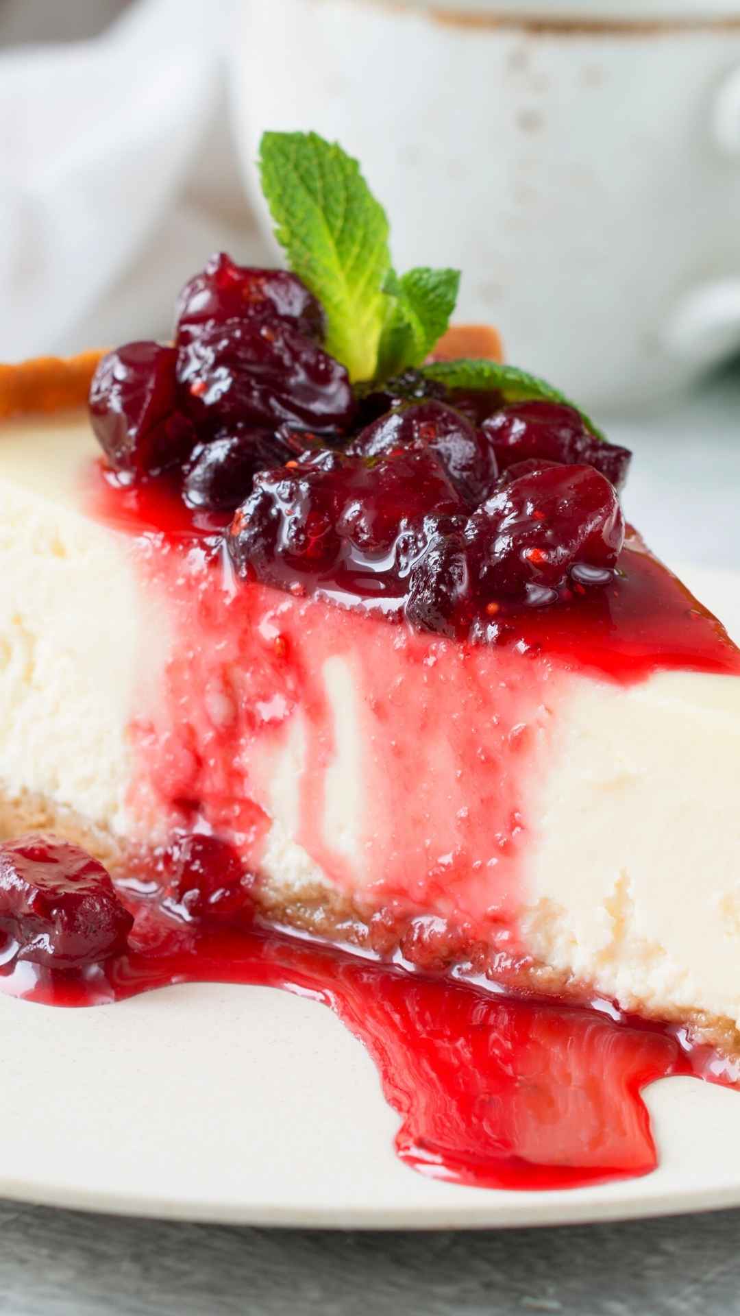 New York Cranberry Cheesecake with Cranberry Orange glaze and mint leaf on top