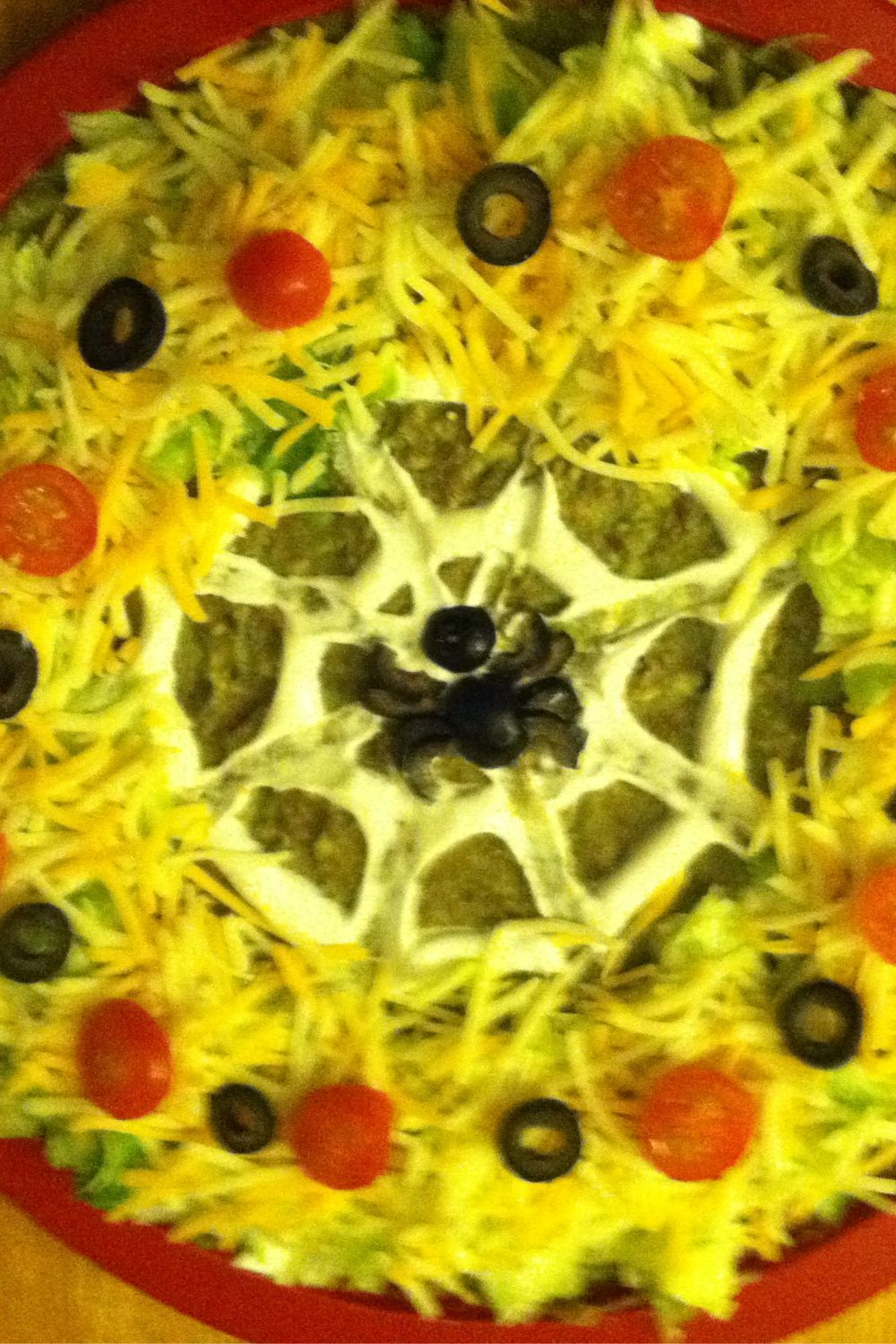 Halloween Spider Web Taco Dip topped with faux edible spider made with black olives