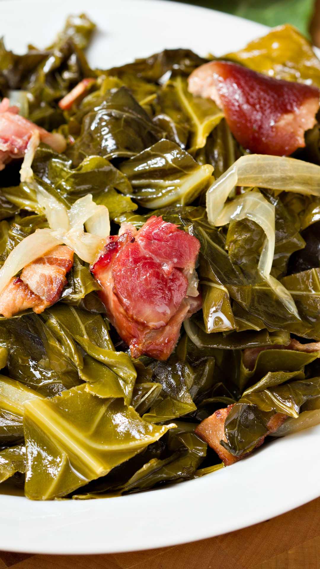 cooked collard greens with tasso and bacon on top