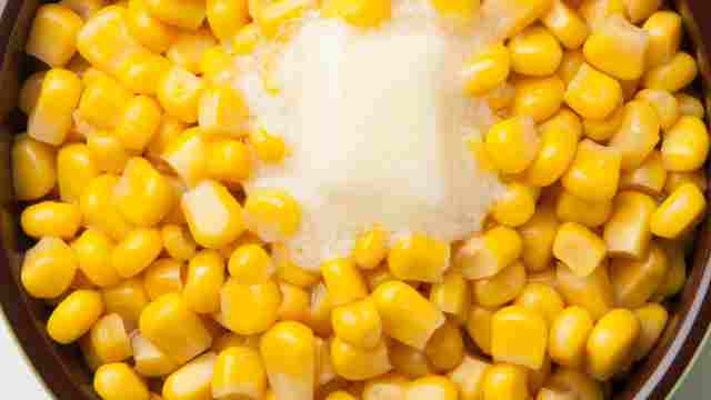 adding corn to the skillet along with butter