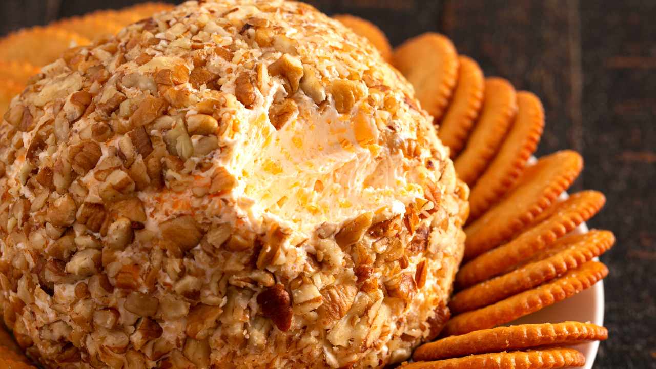 cheese ball coated in nuts served over crackers