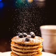 gingerbread pancakes with blueberries on top and sugar dusted on top