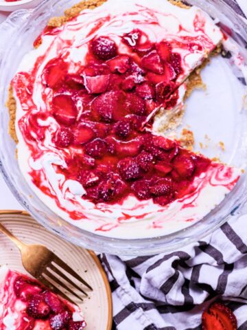 strawberry cream cheese pie in a pie dish with a slice of pie cut out