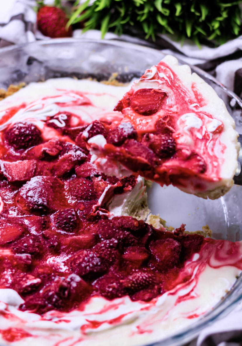 cutting out a slice of strawberry pie with cream cheese pie