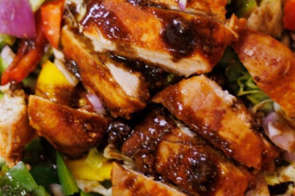 hot honey chicken salad served on a black plate