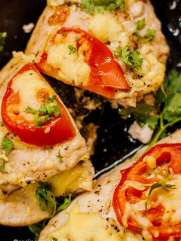 spinach and cheddar stuffed chicken breast topped with cheese and tomato