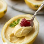 Lemon Posset topped with raspberry in a lemon shell