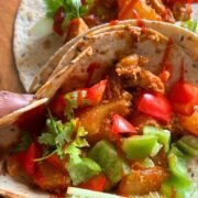hawaiian chicken tacos served and a hand holding it
