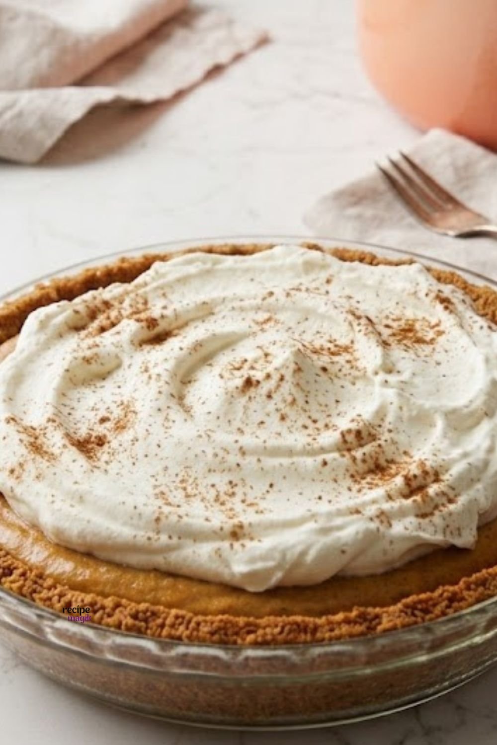 Serving slice of pumpkin chiffon pie topped with homemade whipped cream