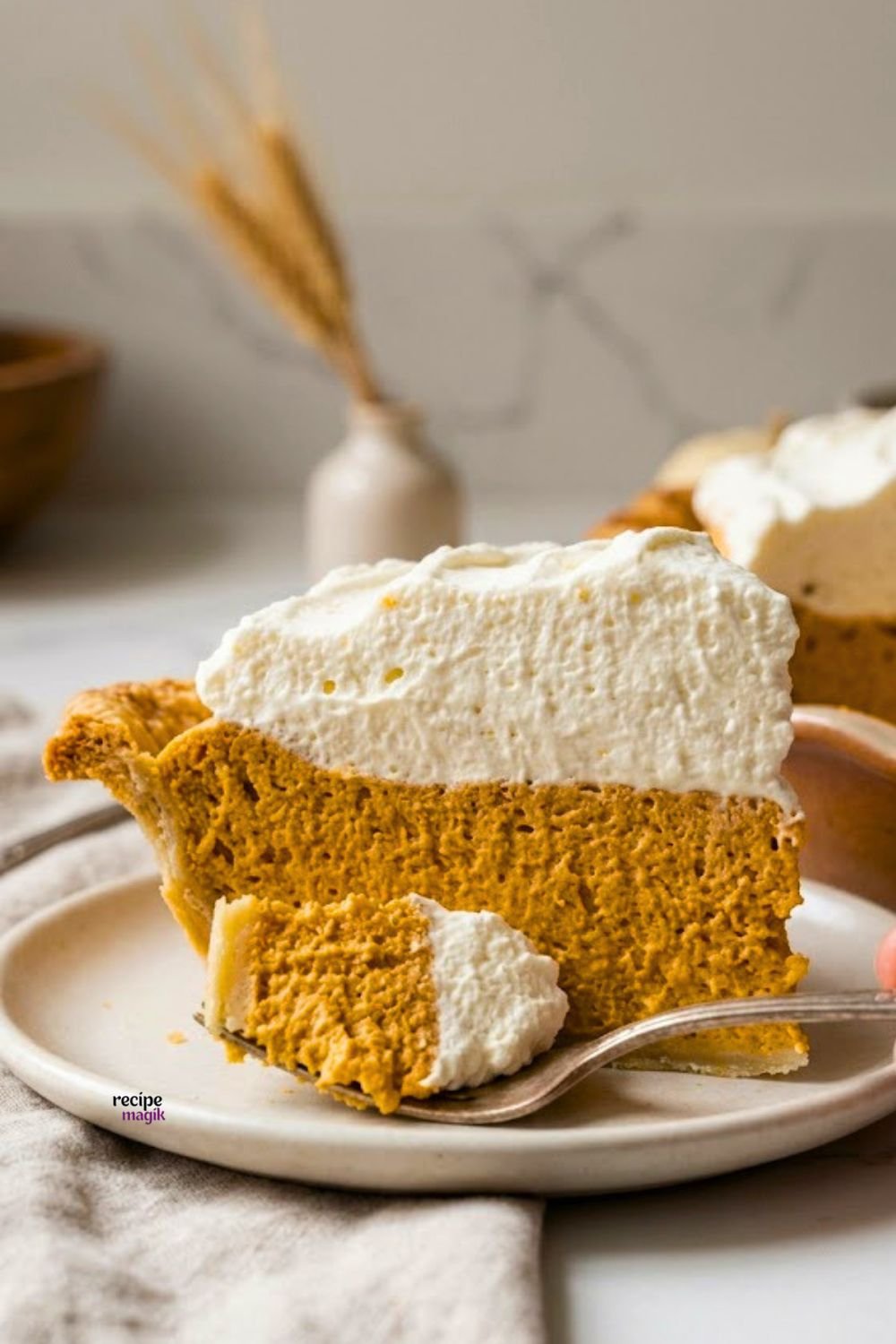 Slice of homemade grandma's pumpkin chiffon pie with a gingersnap crust and whipped cream